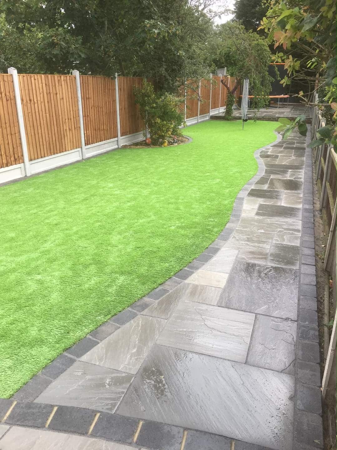 Sandstone path between lawns leading to a shed