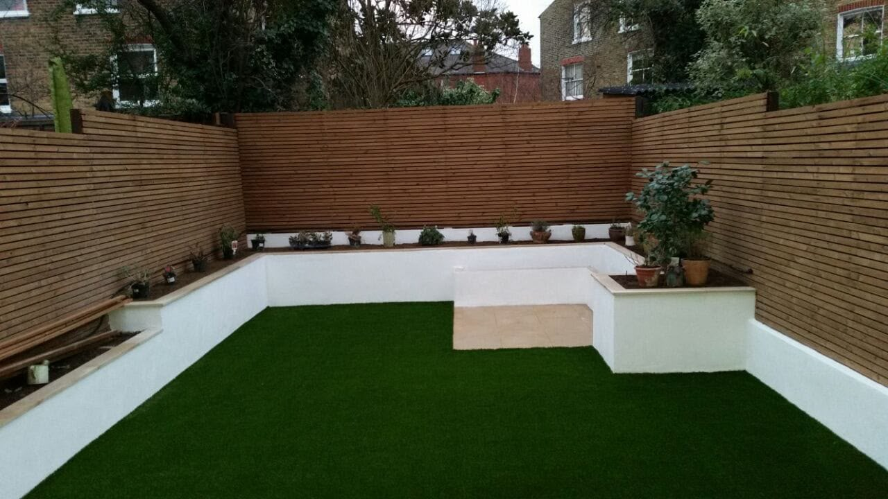 Artificial lawn with rendered raised beds and slatted timber fencing