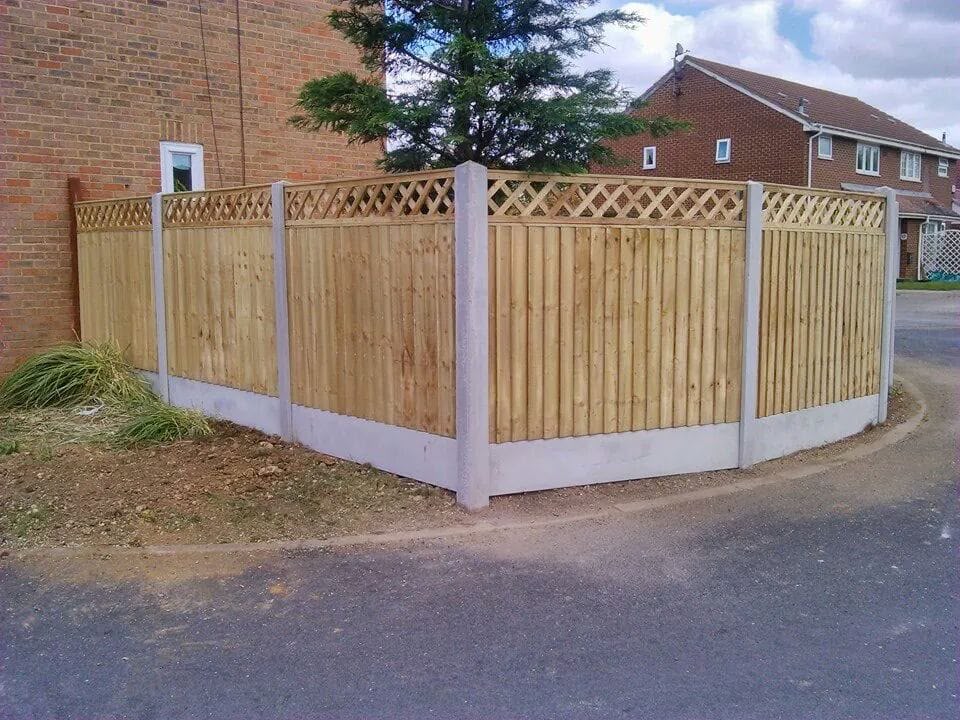 Trellis-topped panel fencing with concrete posts and gravel boards