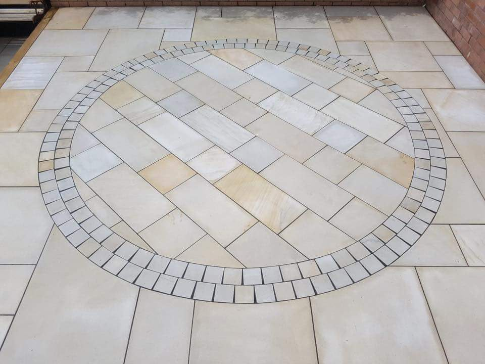 Sandstone patio with circular feature and setts border