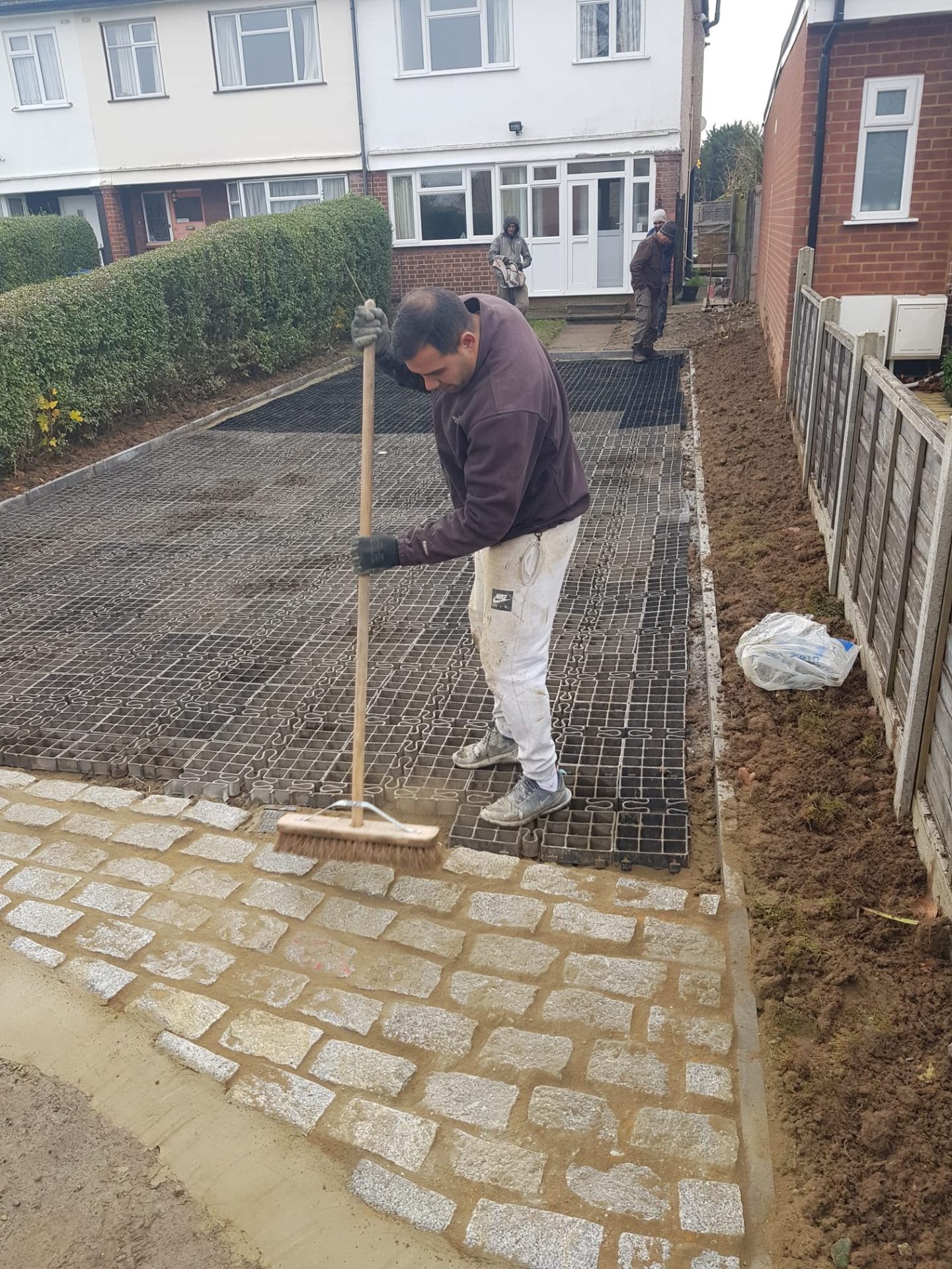 Charcoal herringbone block-paved driveway with darker border course at a modern English brick home