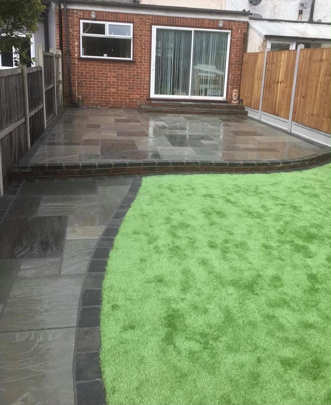 Sandstone patio flowing into artificial lawn