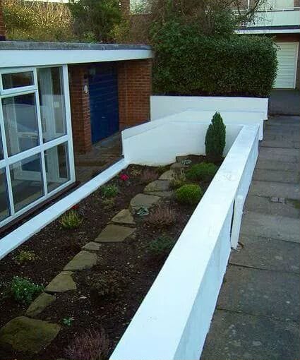 After — Old red brick front wall rebuilt and rendered in white